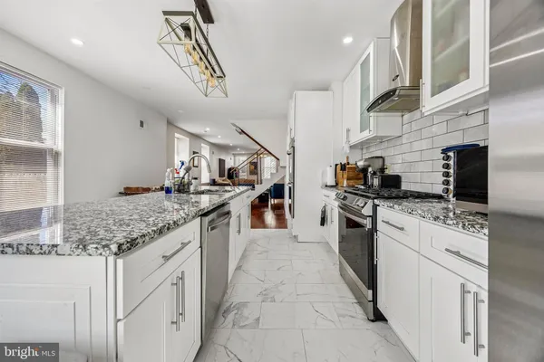 a kitchen with stainless steel appliances granite countertop a sink and stove