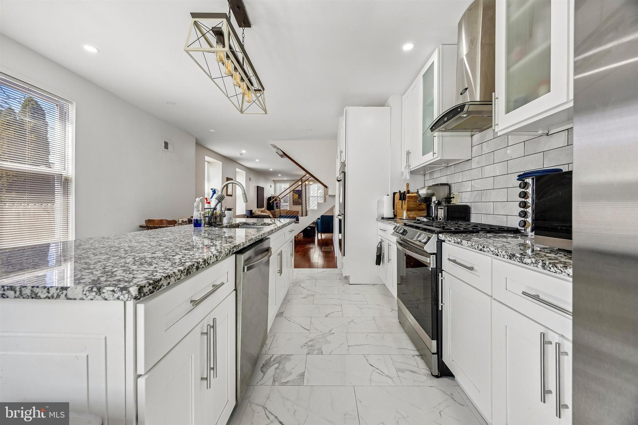 217 Grape Street Philadelphia, PA 19128 - Photo 8 of 27 a kitchen with stainless steel appliances granite countertop a sink and stove