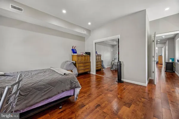 a bedroom with a bed and wooden floor