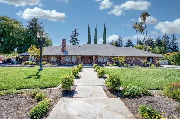 a front view of a house with garden and a yard