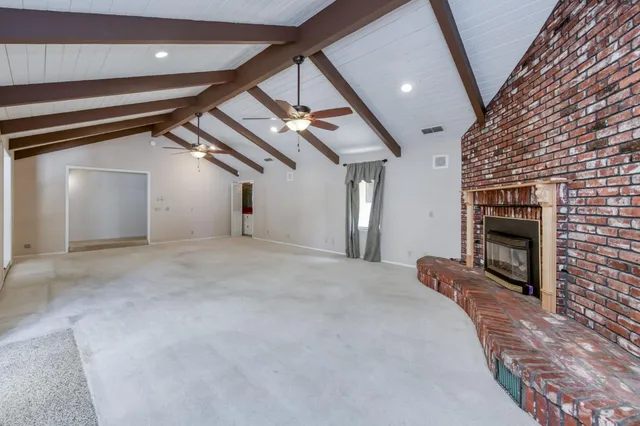 a view of an empty room with a fireplace and a window