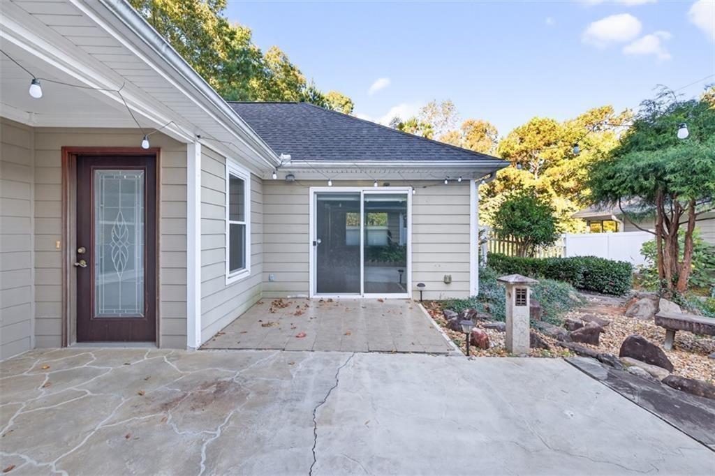164 Cottage Club Drive Locust Grove, GA 30248 - Photo 11 of 56 a backyard of a house with table and chairs under an umbrella