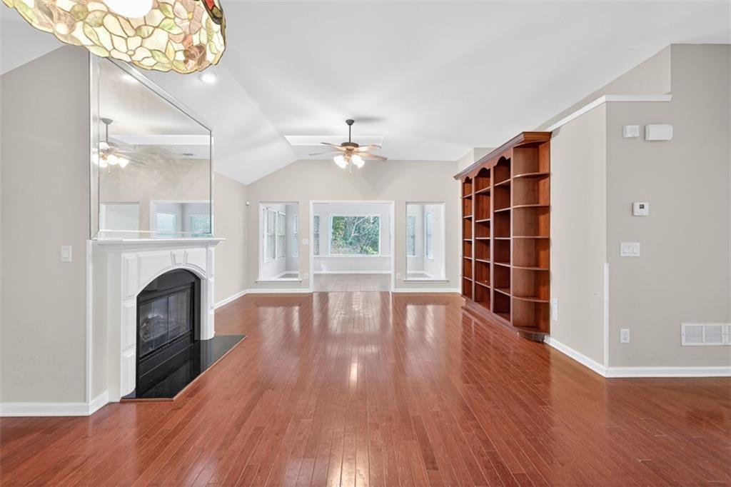 164 Cottage Club Drive Locust Grove, GA 30248 - Photo 13 of 56 wooden floor fireplace and windows in an empty room