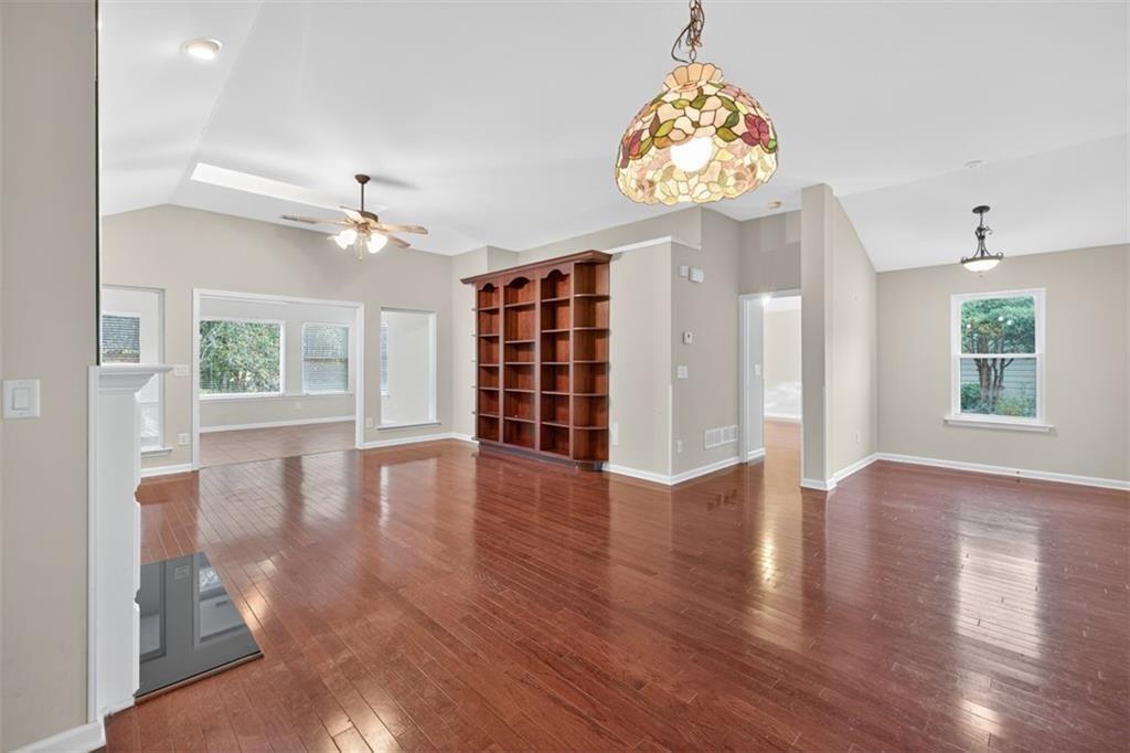 164 Cottage Club Drive Locust Grove, GA 30248 - Photo 14 of 56 an empty room with wooden floor chandelier and windows