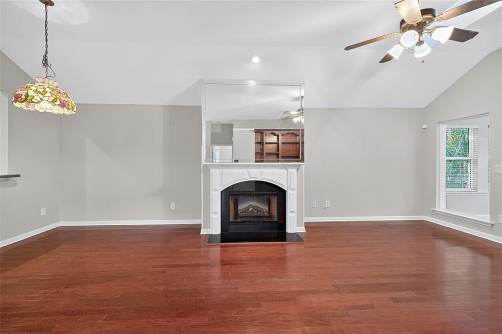 164 Cottage Club Drive Locust Grove, GA 30248 - Photo 17 of 56 a view of a livingroom with a fireplace a ceiling fan and windows