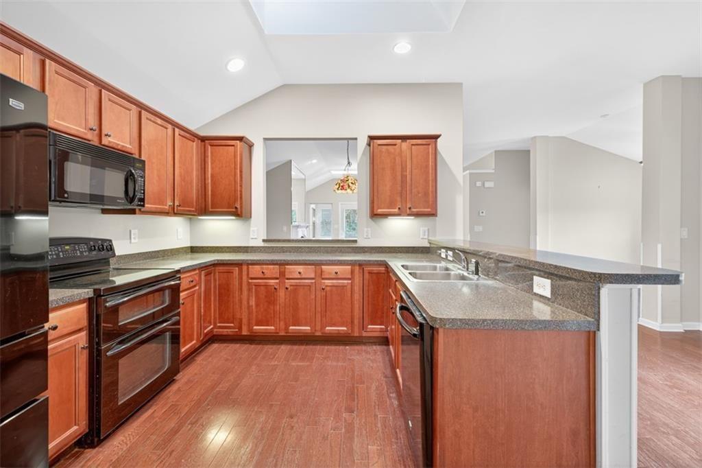 164 Cottage Club Drive Locust Grove, GA 30248 - Photo 24 of 56 a kitchen with stainless steel appliances granite countertop wooden cabinets a sink and dishwasher a stove with wooden floor