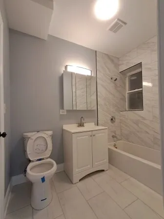 an empty room with wooden floor and a bathroom
