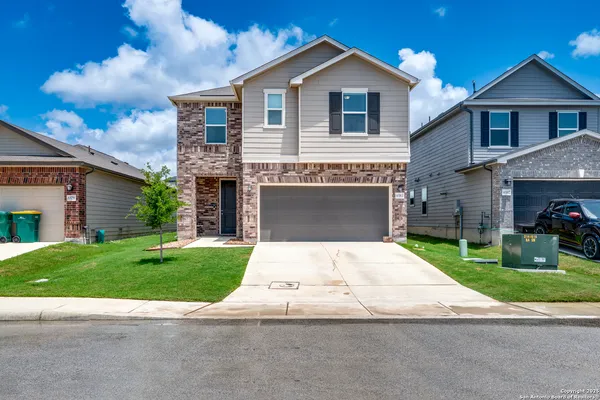 a front view of a house with a yard and garage