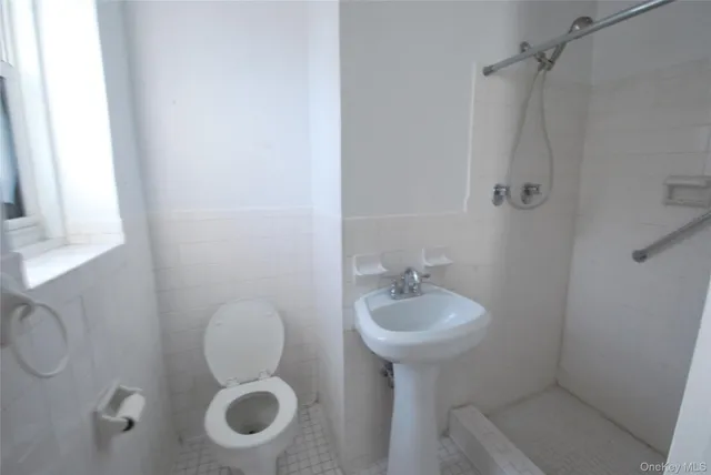 a bathroom with a granite countertop toilet sink and mirror
