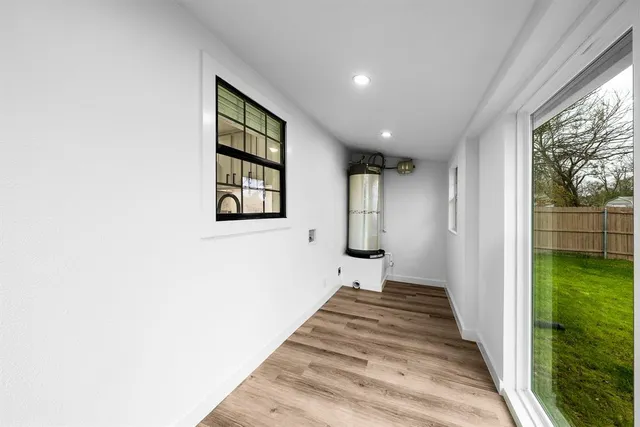 a view of a hallway with wooden floor and a yard