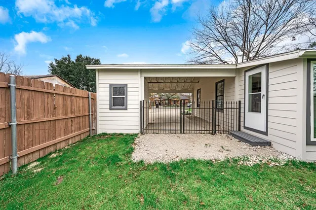a view of backyard with barbeque grill and wooden fence
