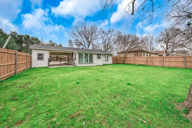 a view of a house with a big yard and large trees