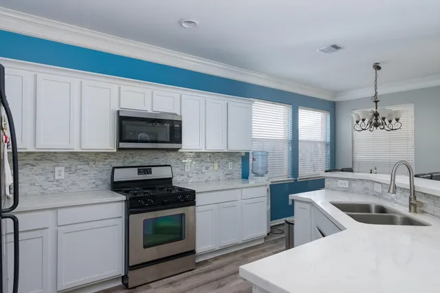 a kitchen with a sink stove and microwave