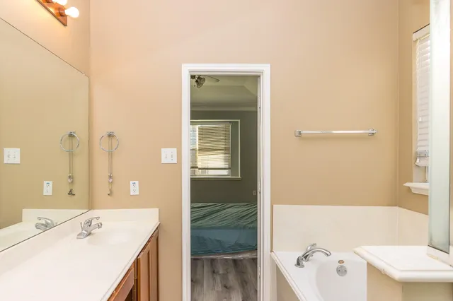 a bathroom with a tub sink and mirror