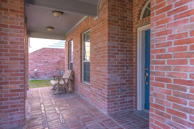 a brick building with a bench and a potted plant