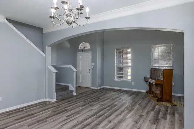 a view of a livingroom with a fireplace a chandelier and wooden floor