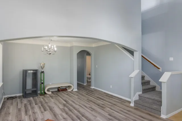 a view of a livingroom with wooden floor and stairs