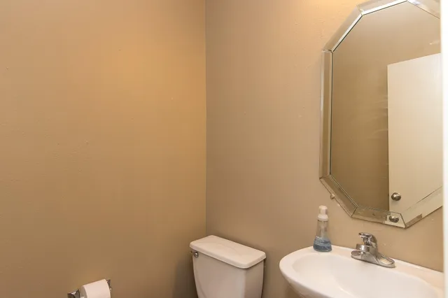a bathroom with a toilet a sink and mirror