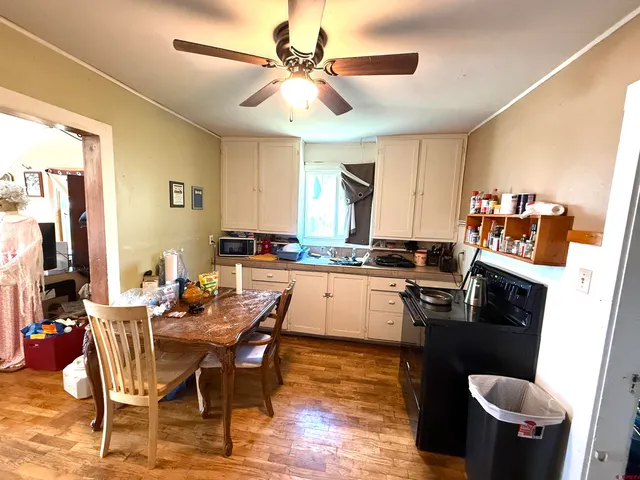 a kitchen with a dining table chairs and a refrigerator