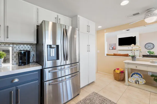 a kitchen with granite countertop a refrigerator and a stove top oven
