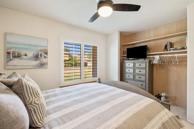 a bedroom with a bed and a flat tv screen on dresser