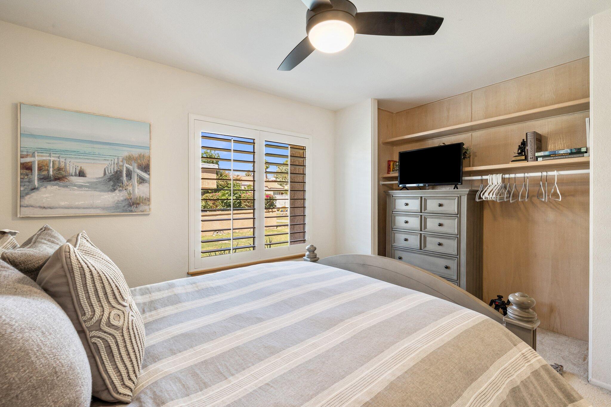 73750 Calle Bisque Palm Desert, CA 92260 - Photo 17 of 40 a bedroom with a bed and a flat tv screen on dresser