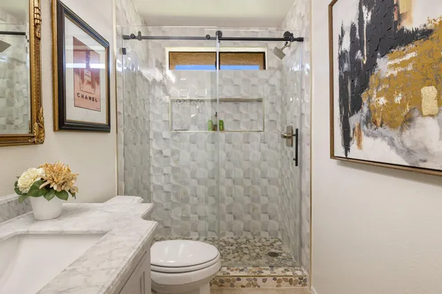 a bathroom with a sink a toilet and shower