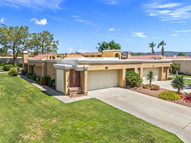 a view of a house with a patio and a yard
