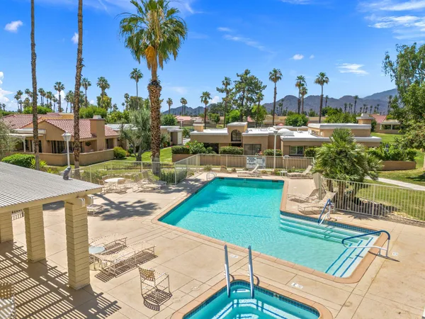 a view of a swimming pool with a patio and a yard