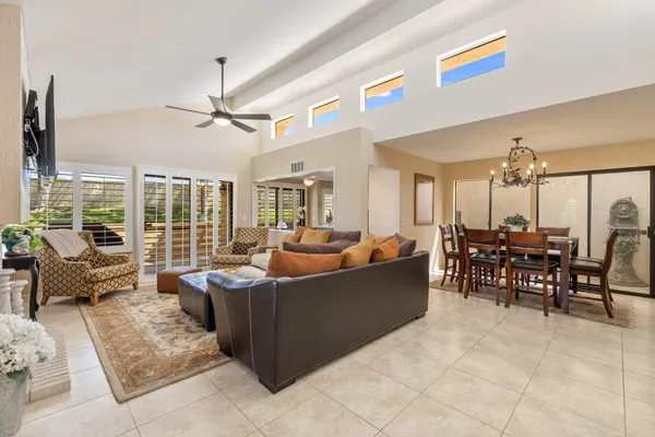 a living room with furniture a chandelier and a dining table