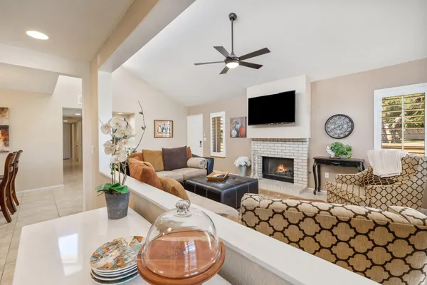 a living room with furniture a flat screen tv and a fireplace