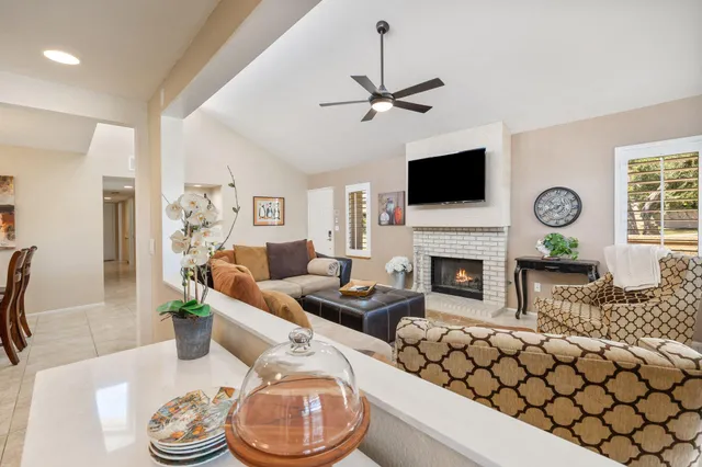 a living room with furniture a flat screen tv and a fireplace