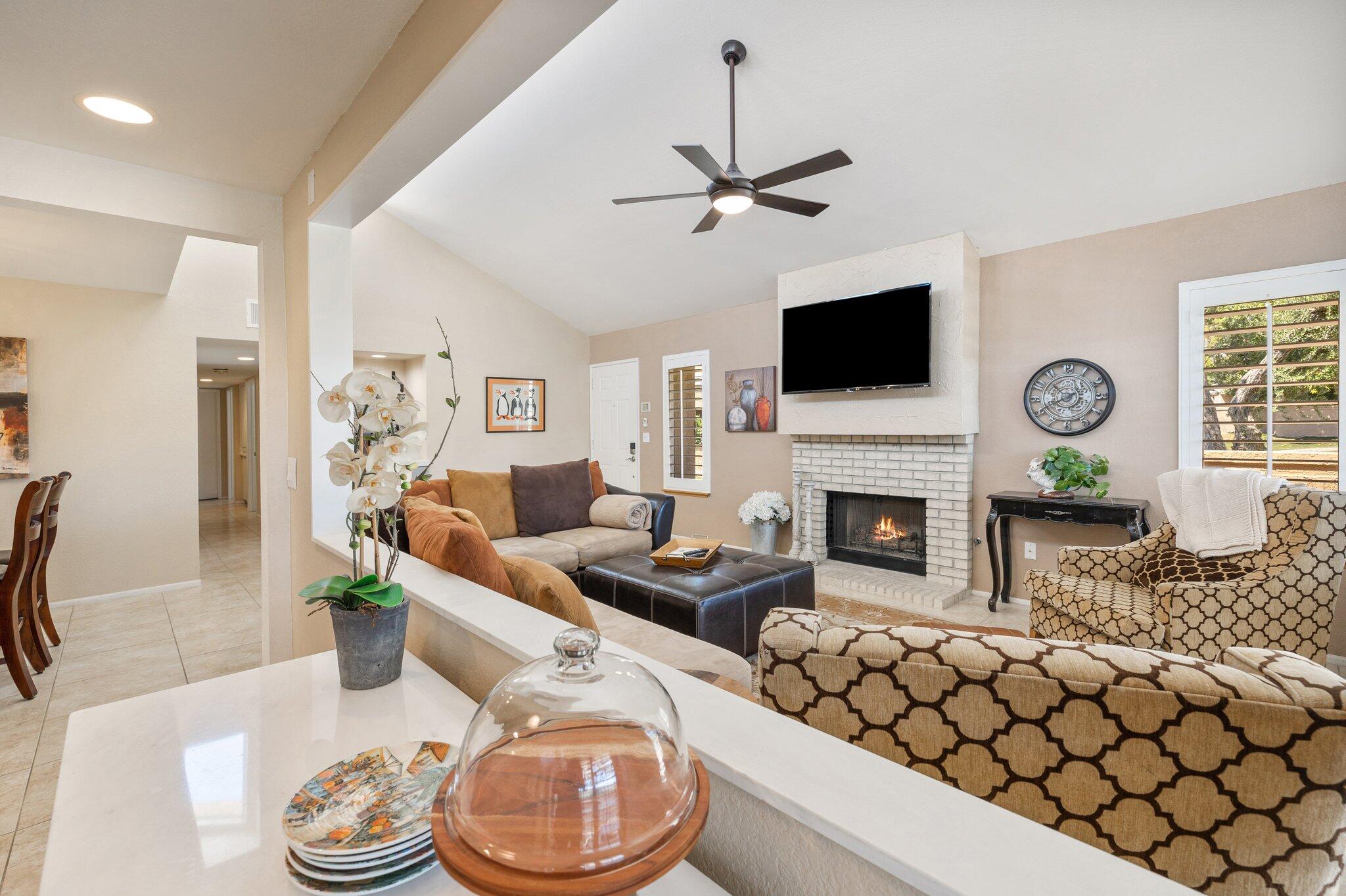 73750 Calle Bisque Palm Desert, CA 92260 - Photo 8 of 40 a living room with furniture a flat screen tv and a fireplace