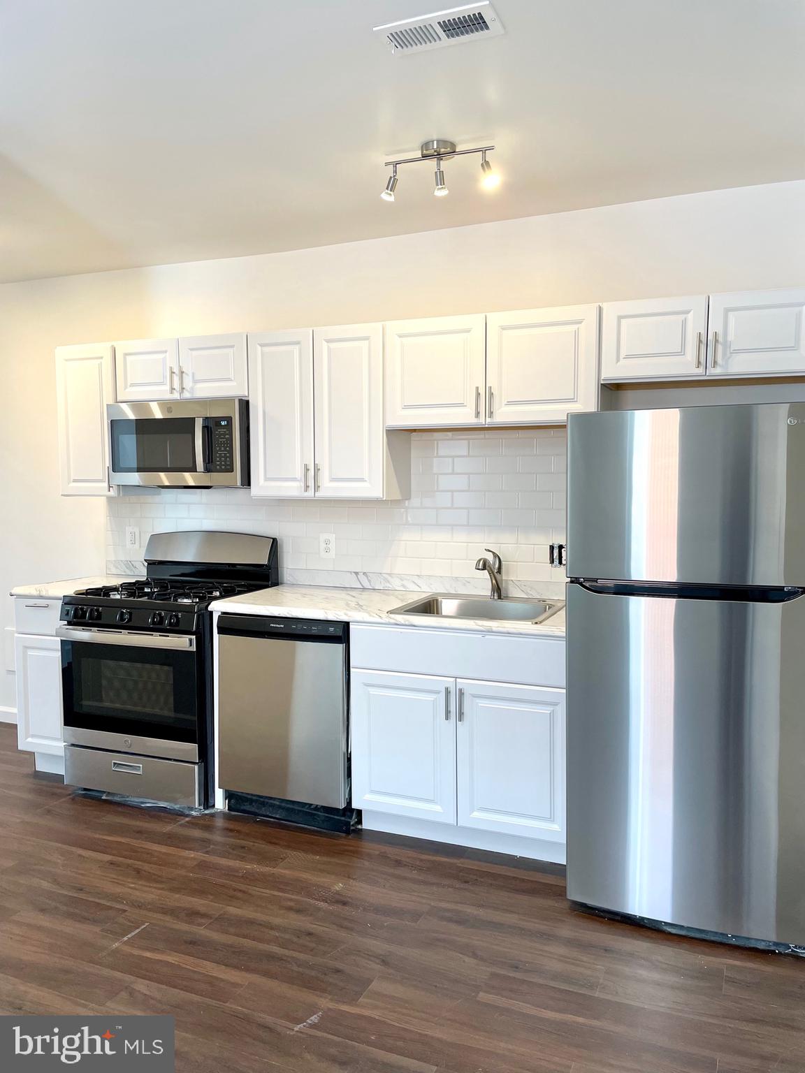 1838 C Street Southeast, Unit 1 Washington, DC 20003 - Photo 2 of 6 a kitchen with a refrigerator and a stove top oven