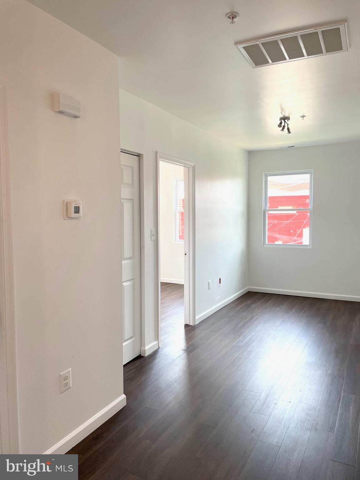 1838 C Street Southeast, Unit 1 Washington, DC 20003 - Photo 4 of 6 an empty room with wooden floor and windows