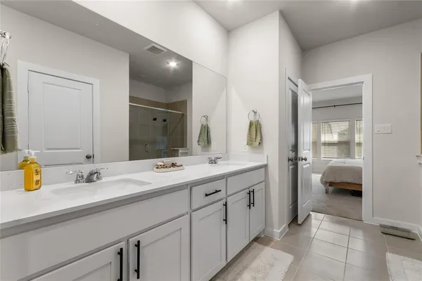 a en suite bathroom with double sink and a large mirror
