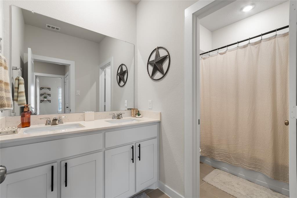797 Vineyard Way Forney, TX 75126 - Photo 19 of 24 a bathroom with a double vanity sink and a mirror