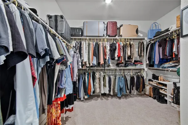 a view of walk in closet with clothes
