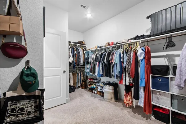 a view of walk in closet with clothes and shoes