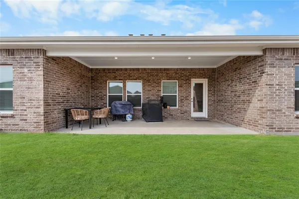 a backyard of a house with table and chairs