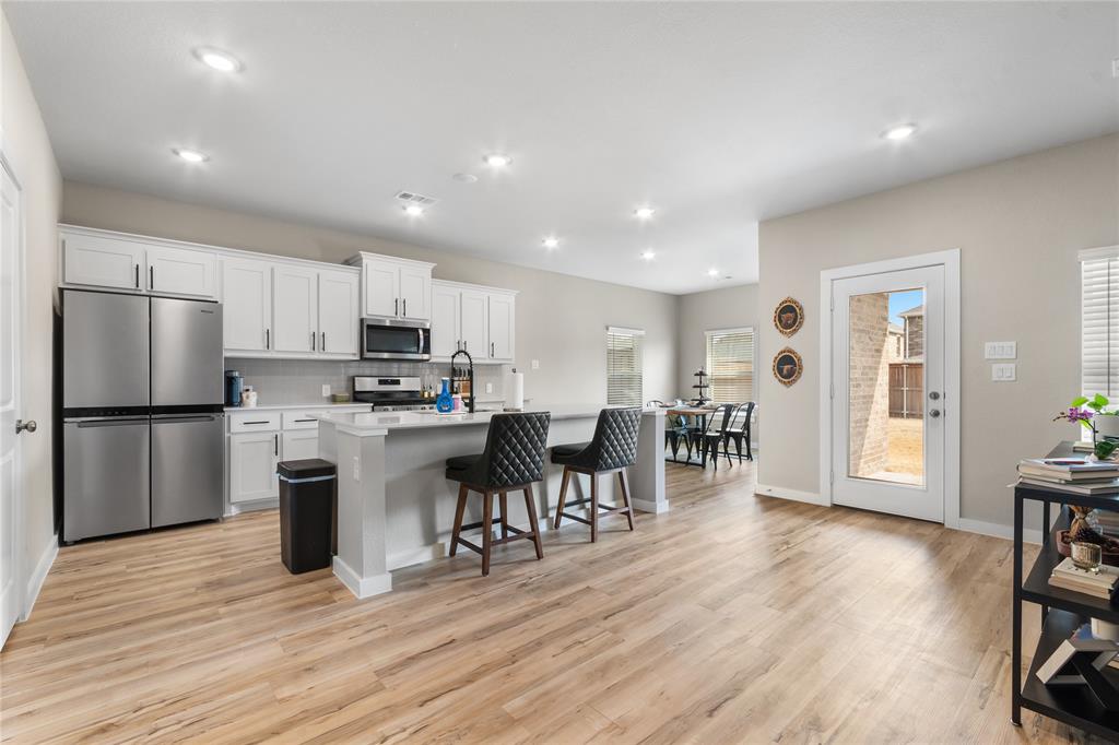 797 Vineyard Way Forney, TX 75126 - Photo 4 of 24 a kitchen with a refrigerator and a dining table