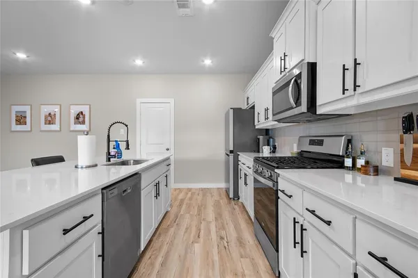 a kitchen with stainless steel appliances a sink stove and cabinets