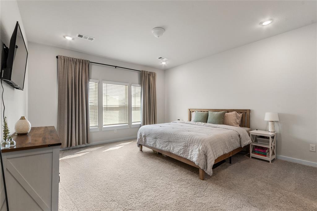 797 Vineyard Way Forney, TX 75126 - Photo 10 of 24 a spacious bedroom with a bed and flat screen tv