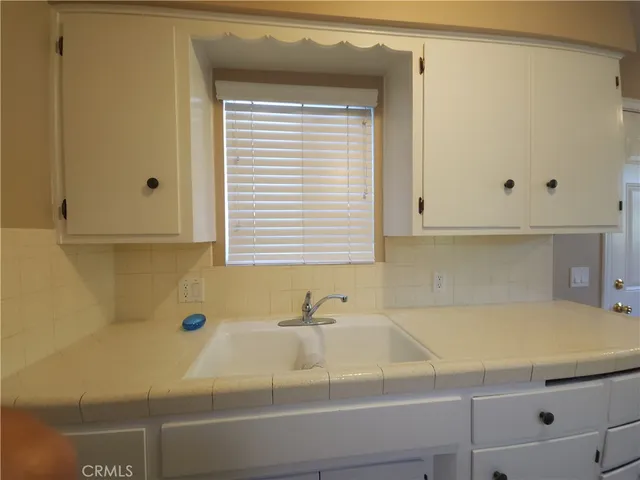 a kitchen with cabinets and stove top oven