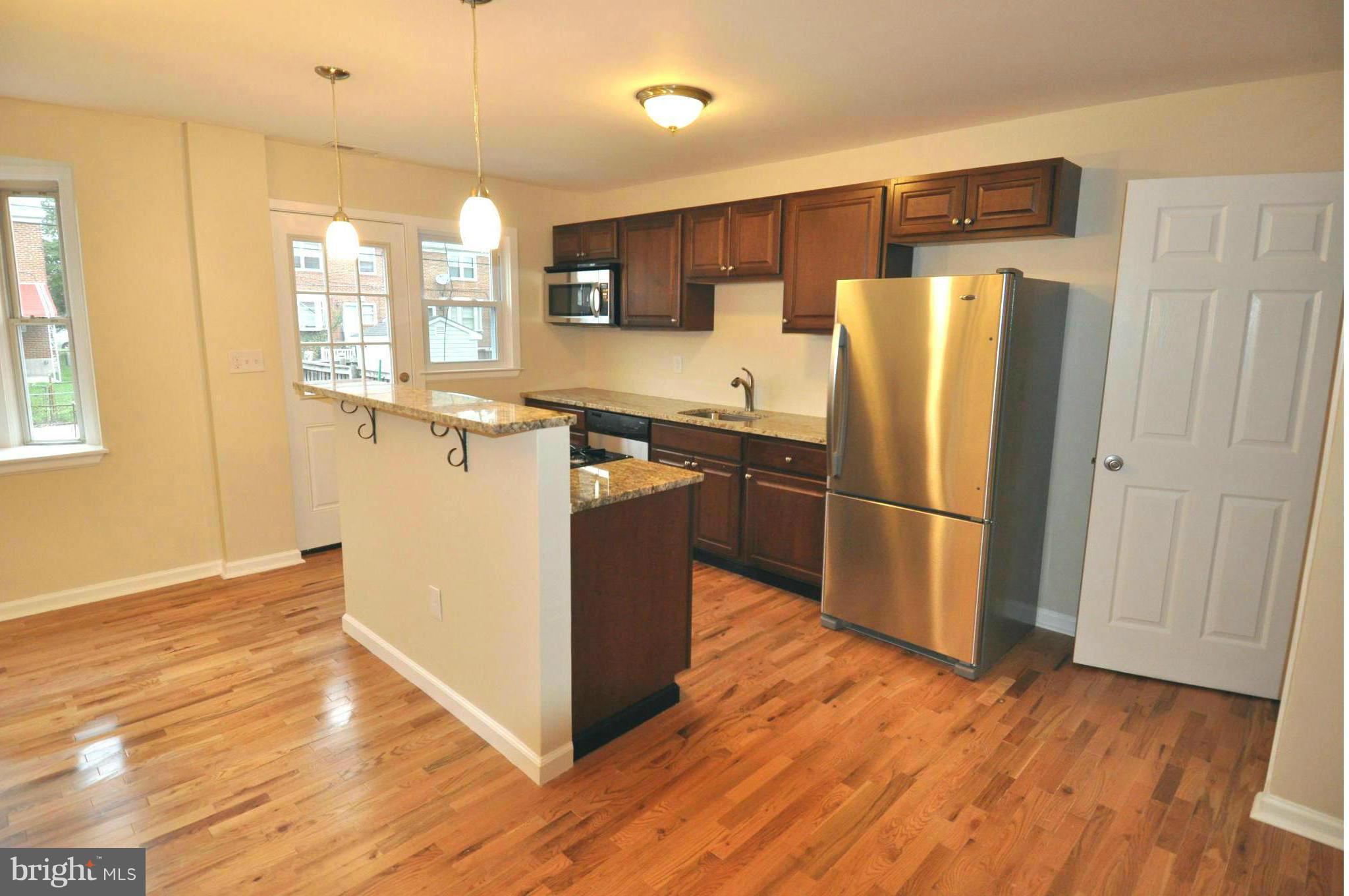 1126 Cedarcroft Road Baltimore, MD 21239 - Photo 1 of 23 a kitchen with stainless steel appliances a refrigerator and wooden floor