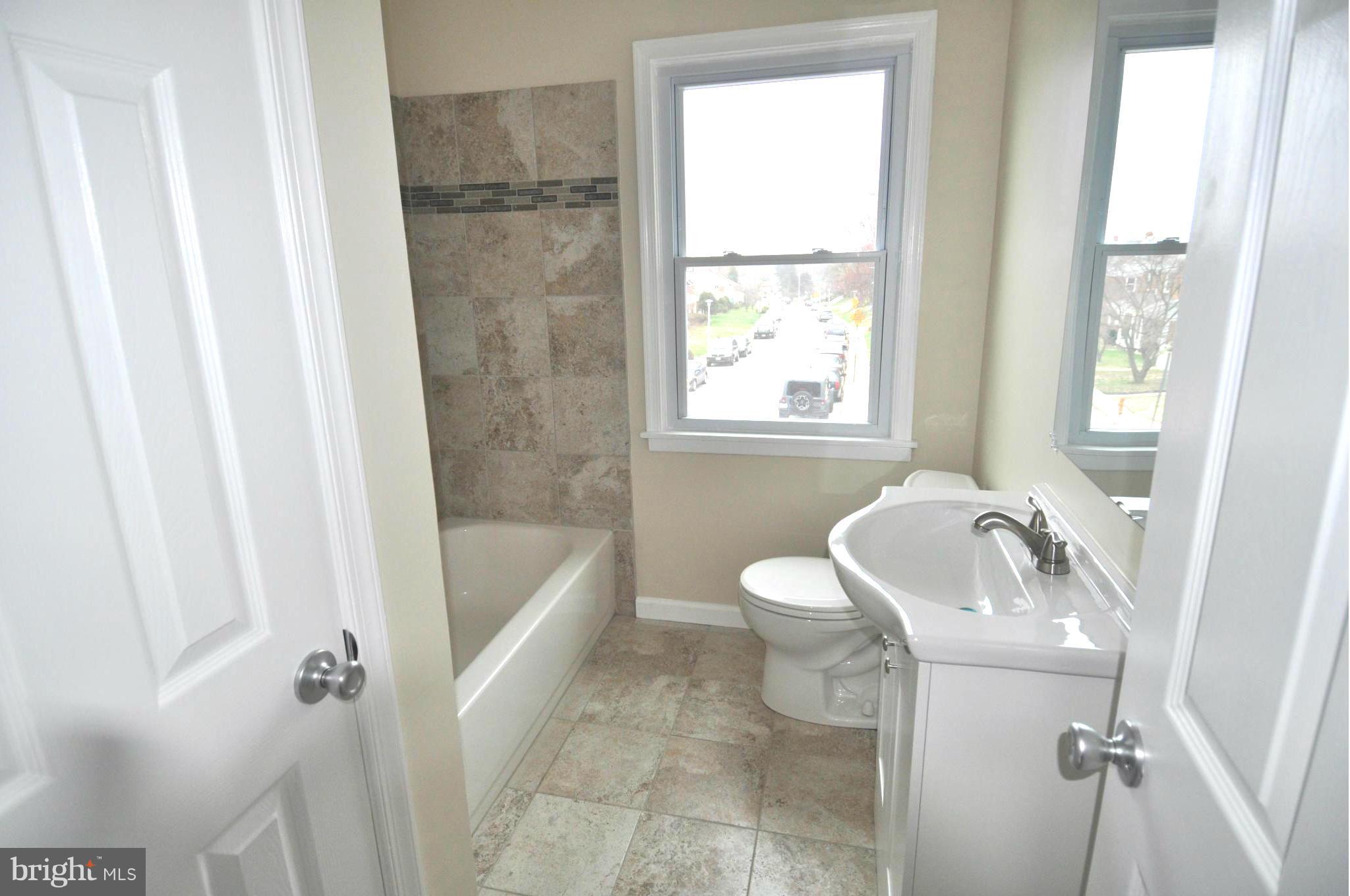 1126 Cedarcroft Road Baltimore, MD 21239 - Photo 14 of 23 a bathroom with a sink a toilet a tub and shower