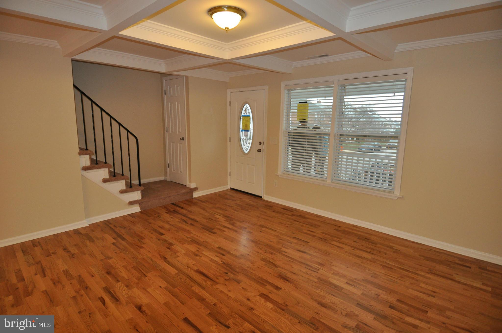 1126 Cedarcroft Road Baltimore, MD 21239 - Photo 3 of 23 a view of an empty room with wooden floor and a window