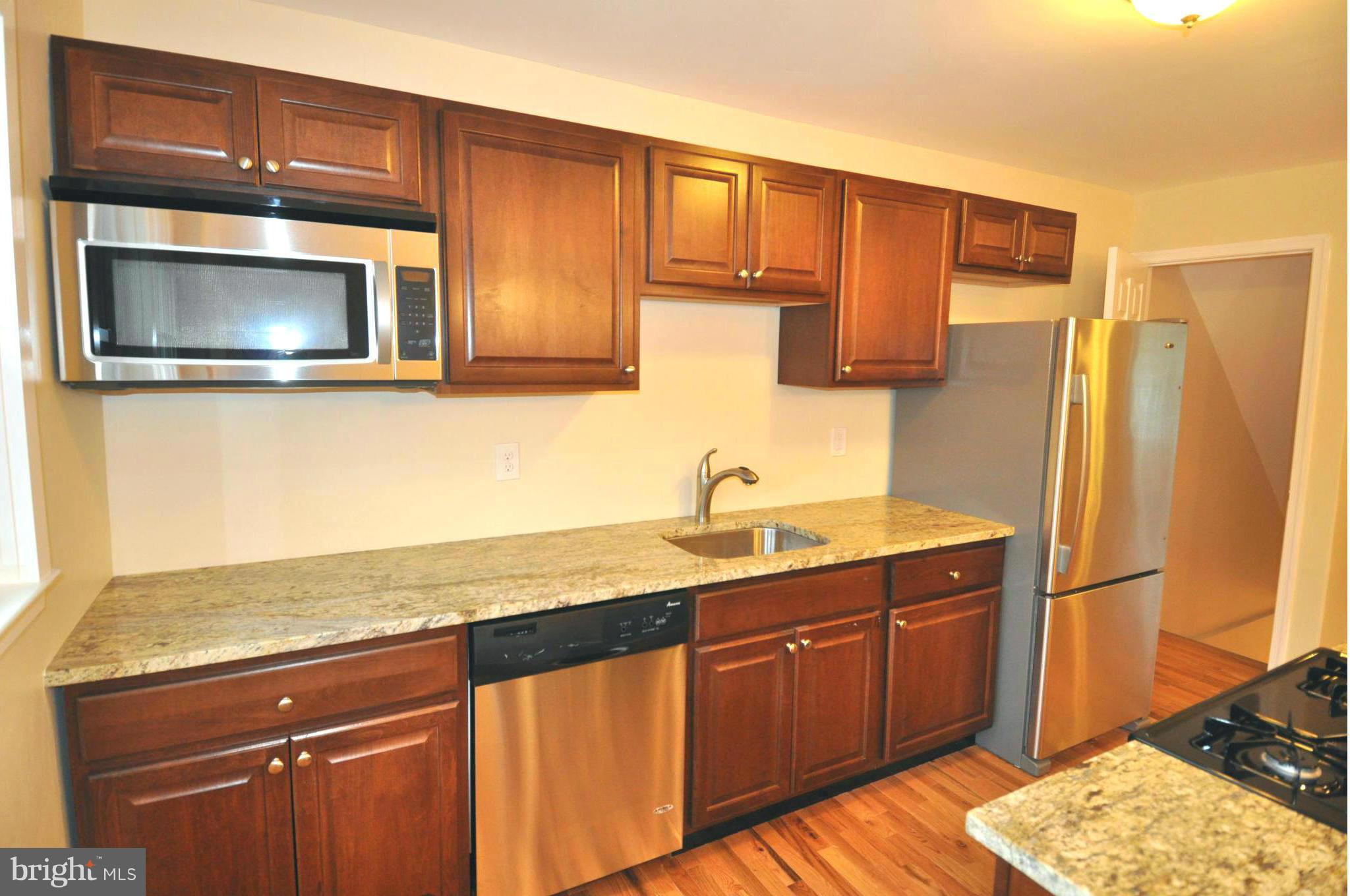1126 Cedarcroft Road Baltimore, MD 21239 - Photo 5 of 23 a kitchen with stainless steel appliances granite countertop a sink stove and refrigerator