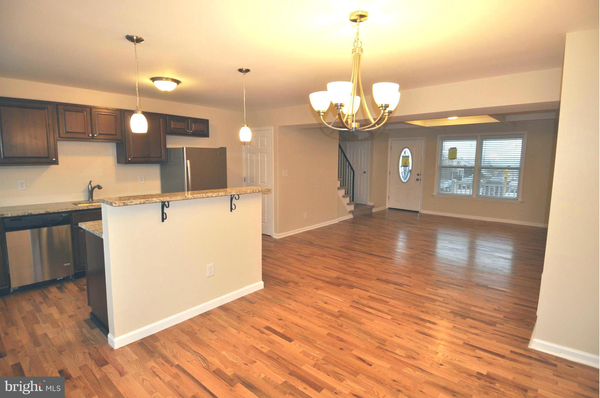 1126 Cedarcroft Road Baltimore, MD 21239 - Photo 9 of 23 a kitchen with a wooden floor and chandelier