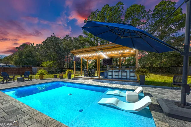 a view of a house with backyard and sitting area